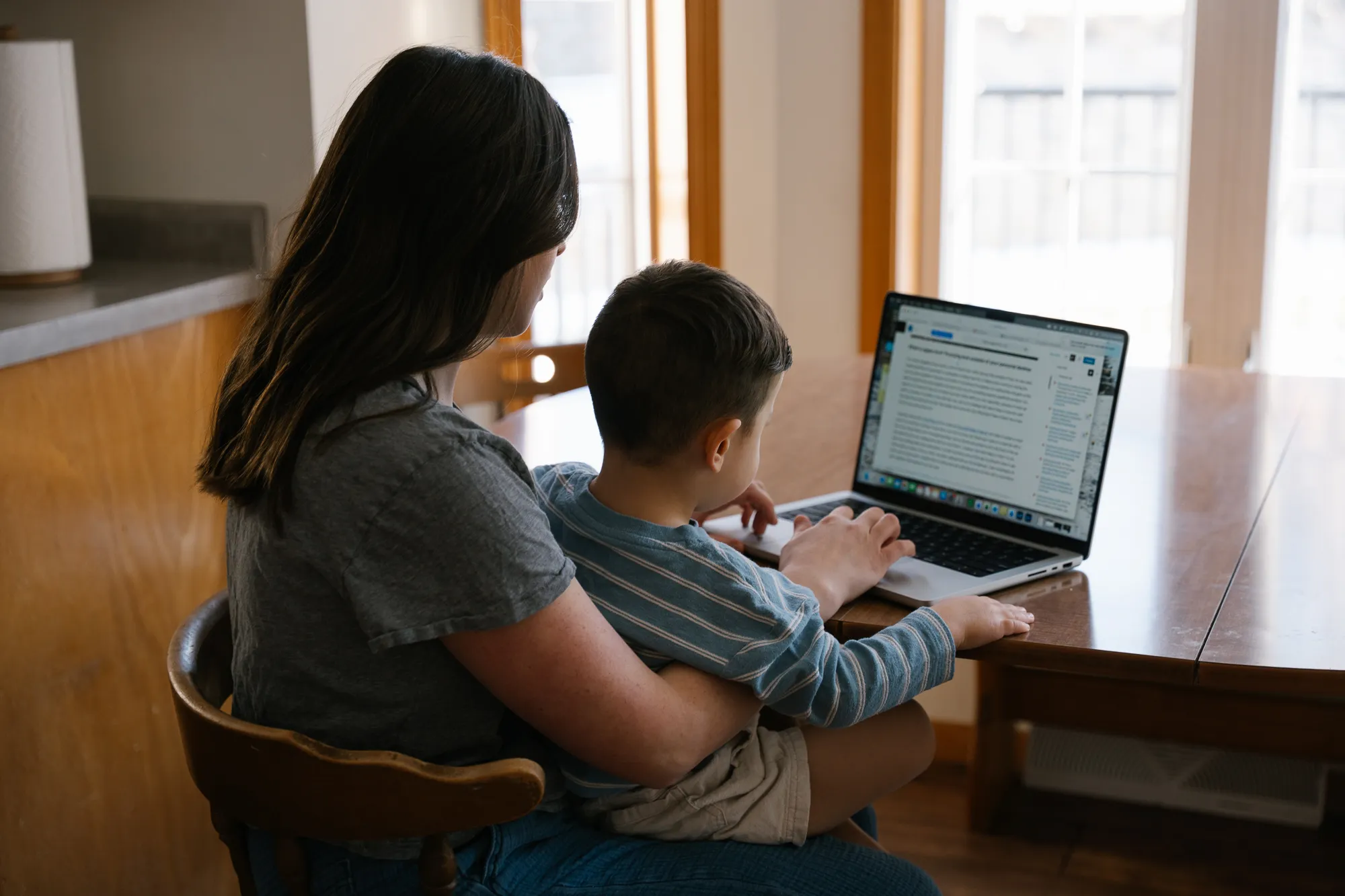 Mom with child studying in her kitchen